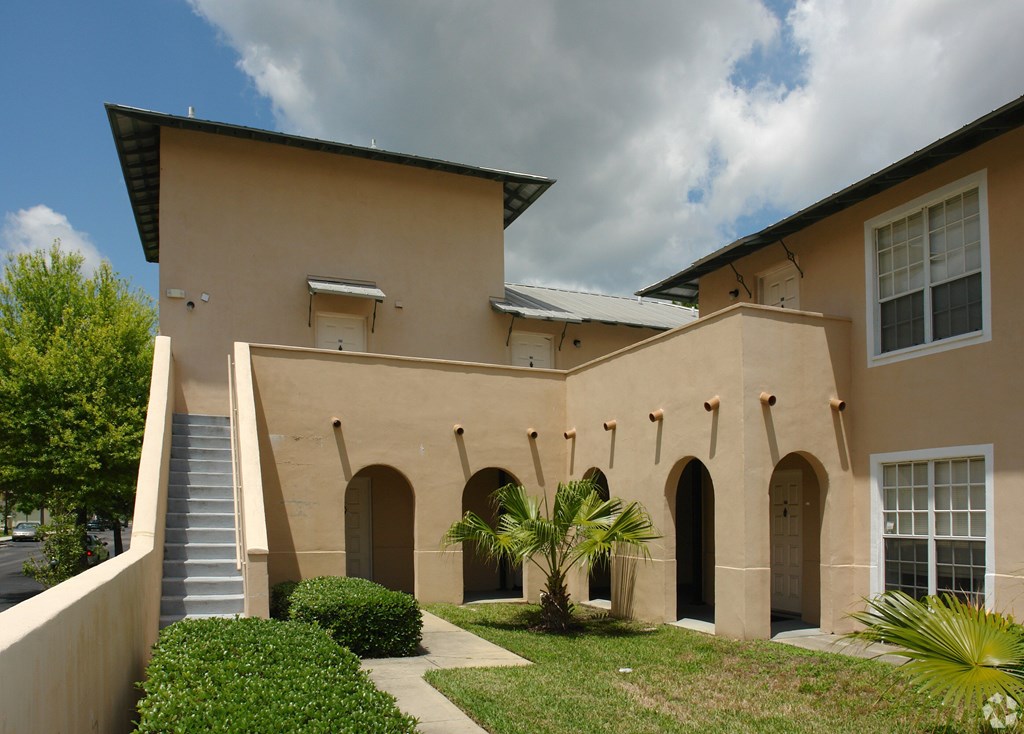 A beige building with a staircase leading to the entrance.