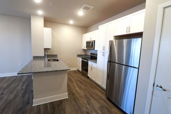 A kitchen with a granite countertop and stainless steel appliances.
