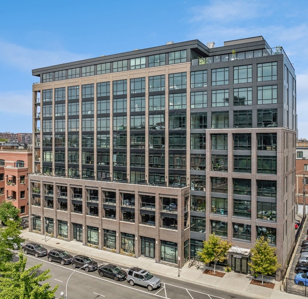 main view of the office building with cars parked in front of it