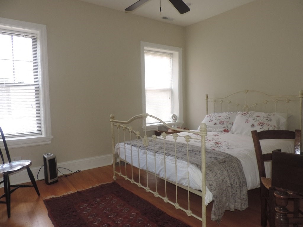 a bedroom with a bed and two windows