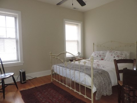 a bedroom with a bed and two windows
