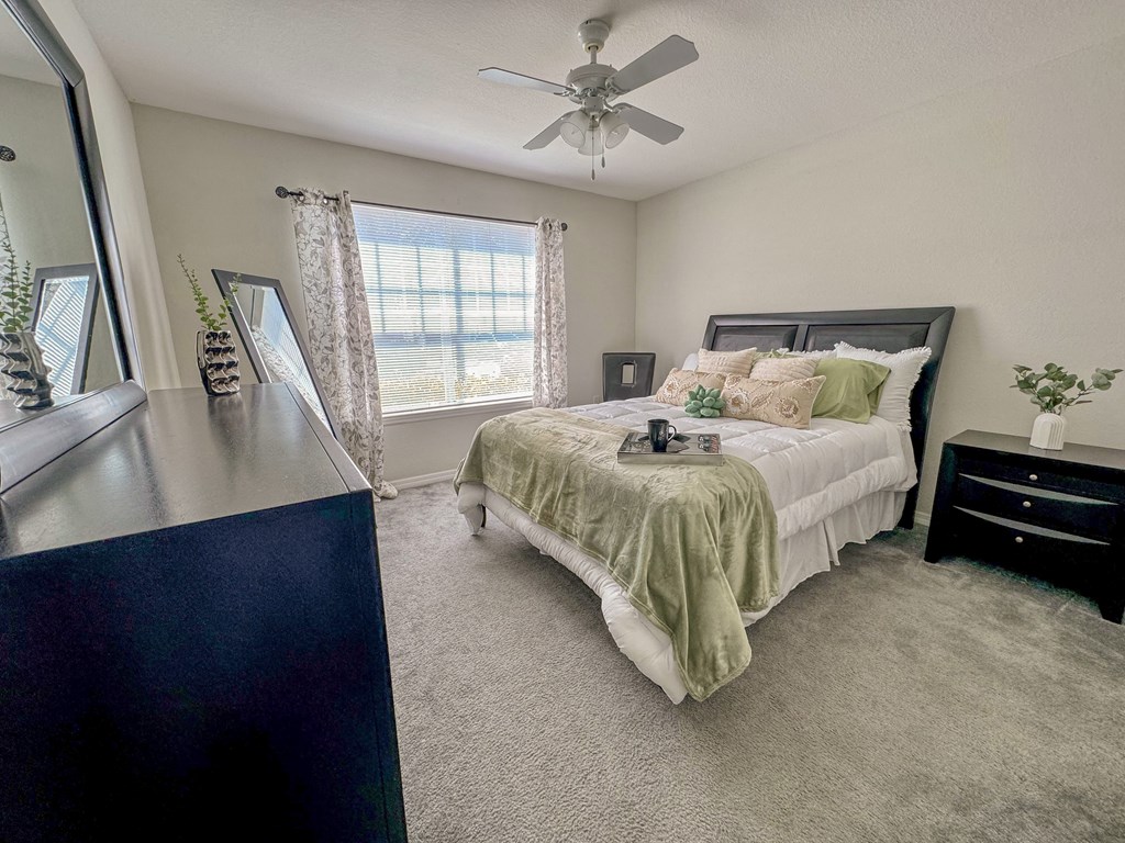 a bedroom with a bed and a ceiling fan