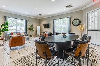A modern dining room with a round table and chairs.