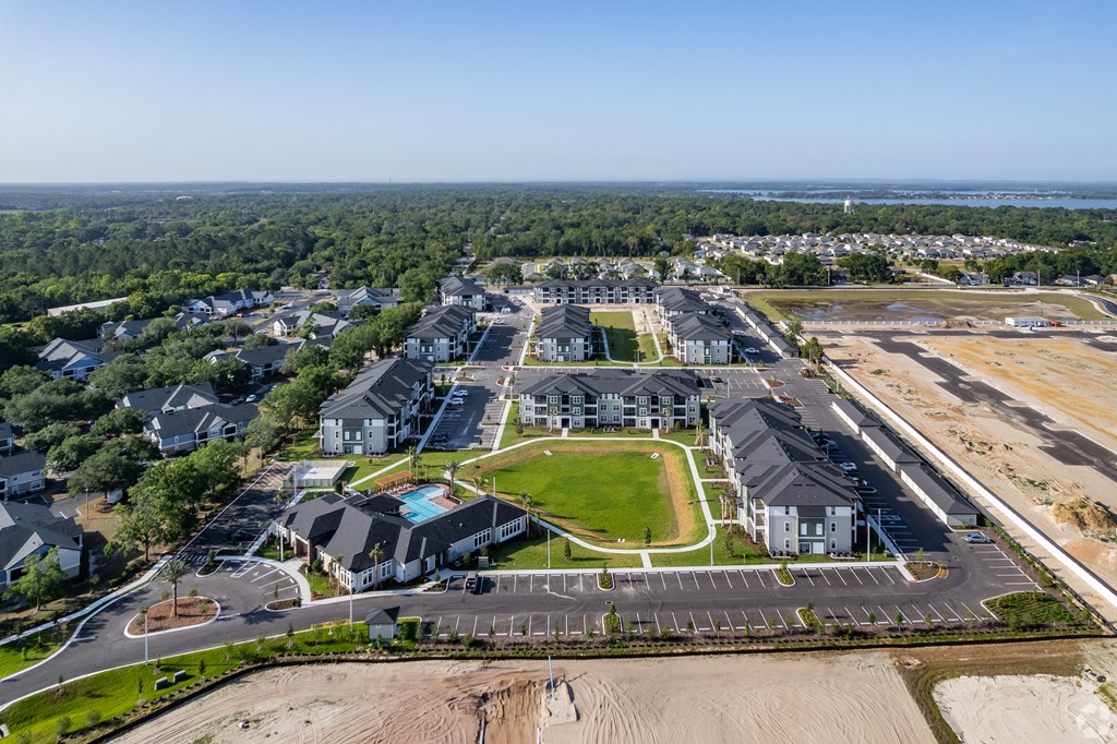 A bird's eye view of a residential area with a large open field in the foreground.