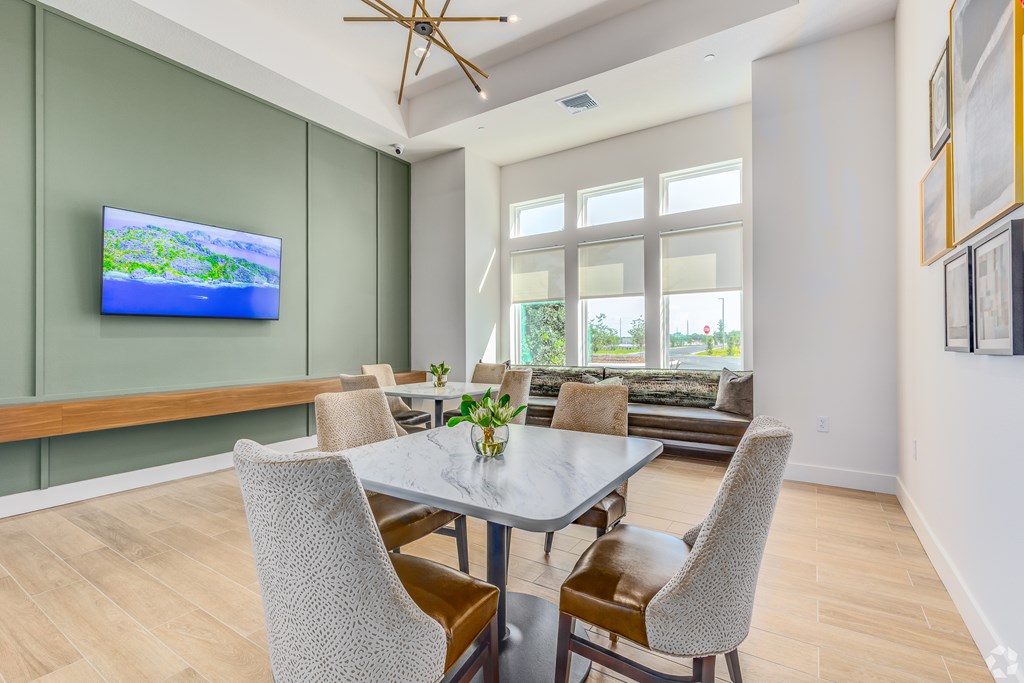 A modern dining room with a glass table and chairs.