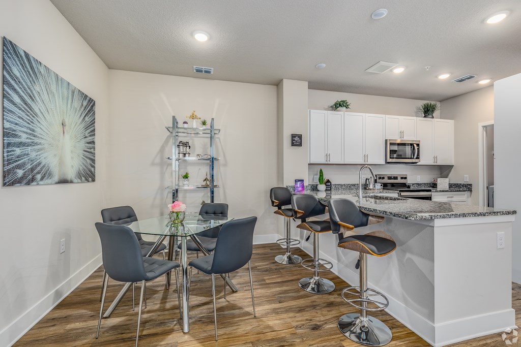 A kitchen with a bar and chairs.