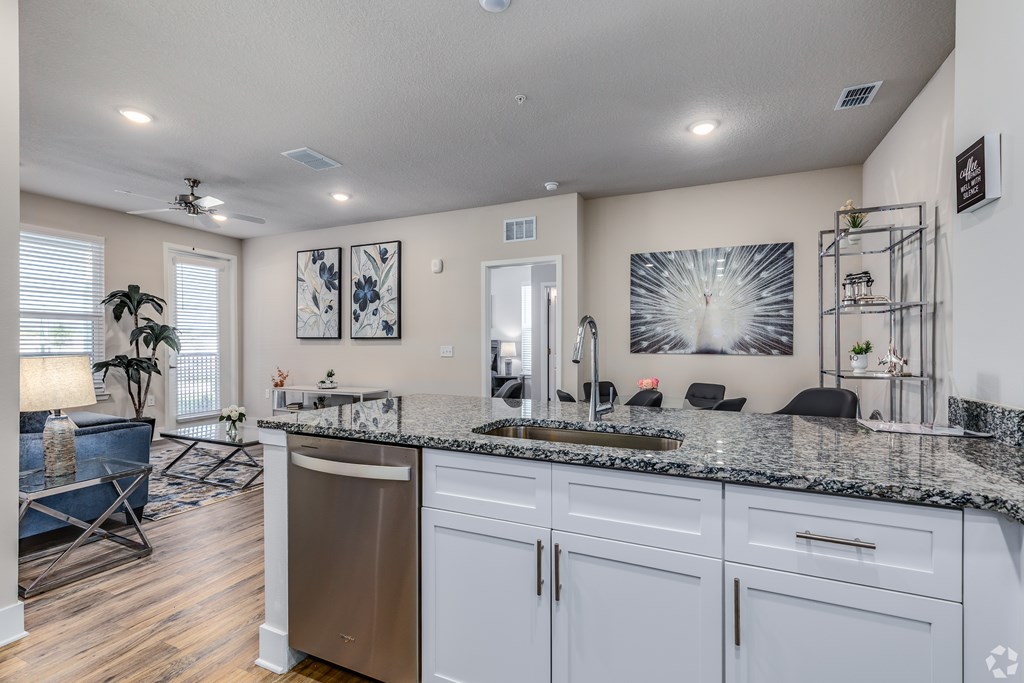 A kitchen with a granite countertop and white cabinets.