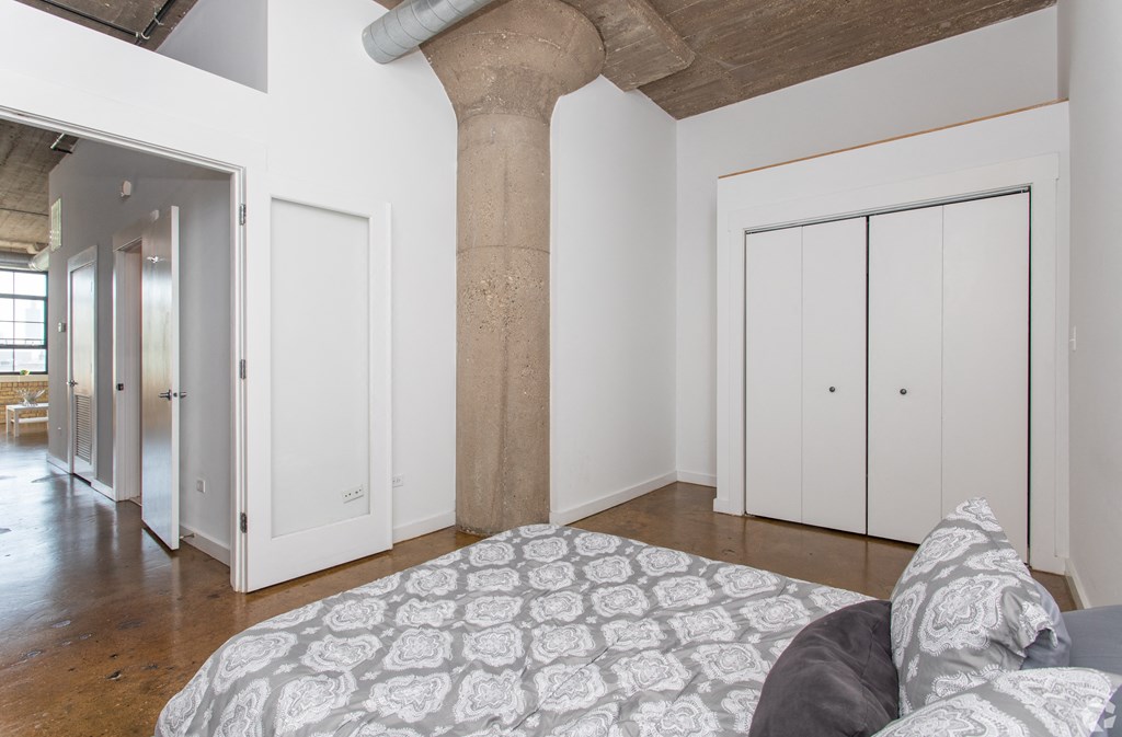 a bedroom with a large column in the middle of it and a bed with a