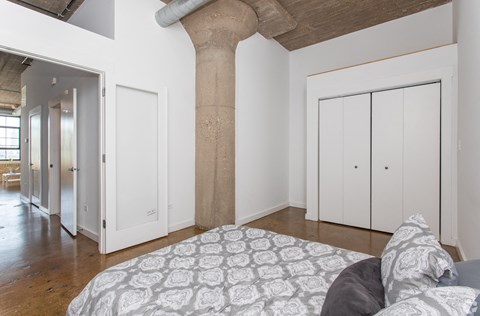 a bedroom with a large column in the middle of it and a bed with a