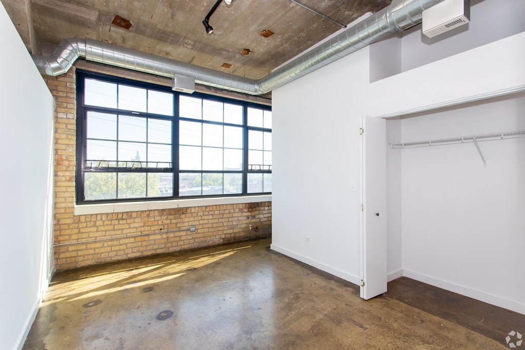 an empty room with a large window and a door