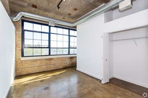 an empty room with a large window and a door