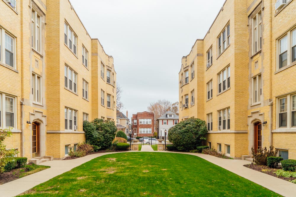 a green lawn in the middle of some apartment buildings