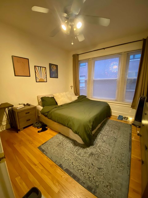 A bedroom with a bed, dresser, and window.