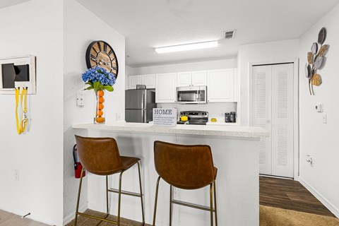 A kitchen with white cabinets and a white counter top.