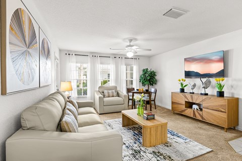 A living room with a beige sofa, a coffee table, and a painting on the wall.
