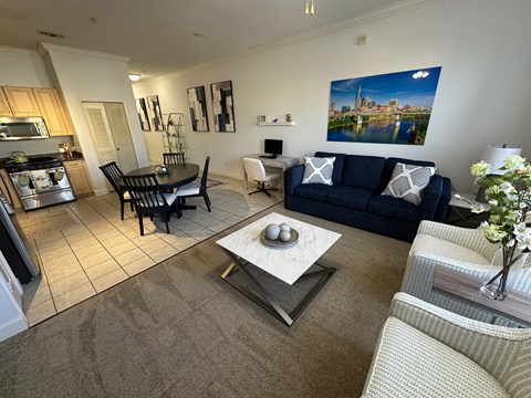 A living room with a blue couch and a coffee table in the center.