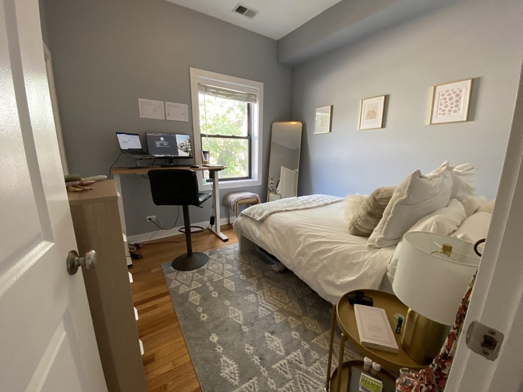 a bedroom with a bed and a desk with a computer