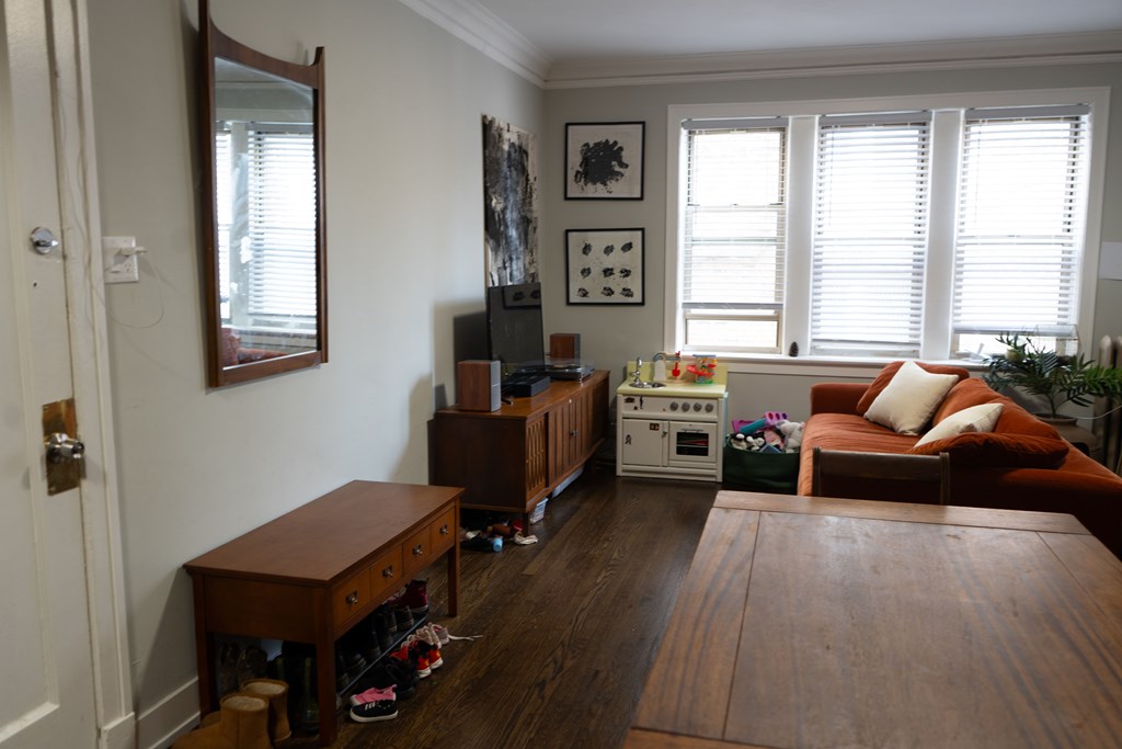A living room with a couch, a table, and a window.