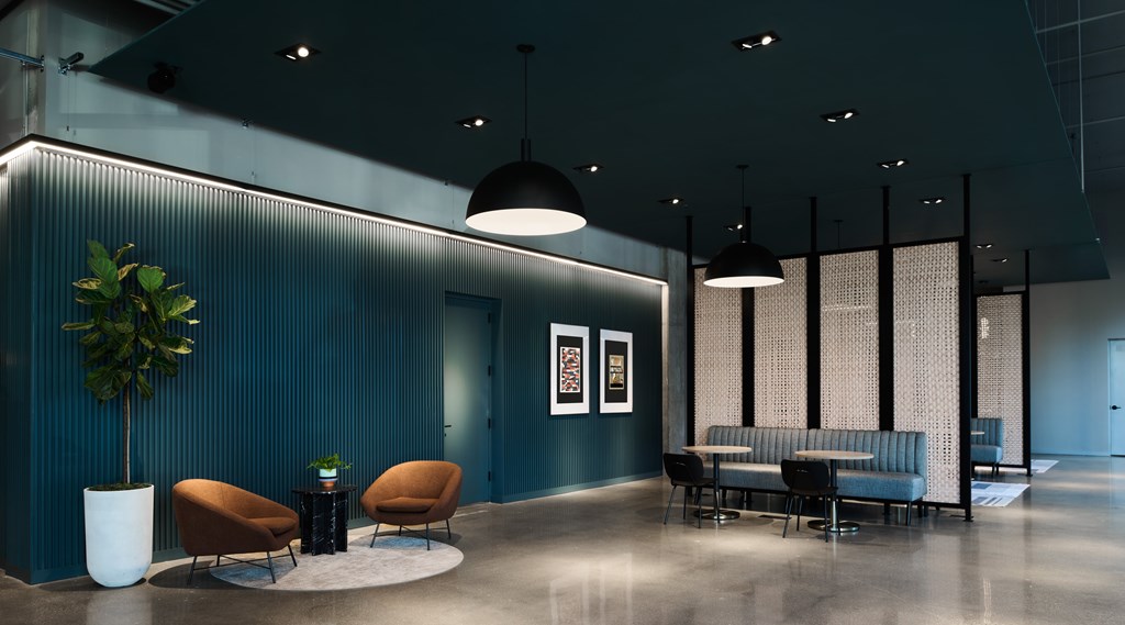 A modern waiting area with a blue wall and comfortable seating.
