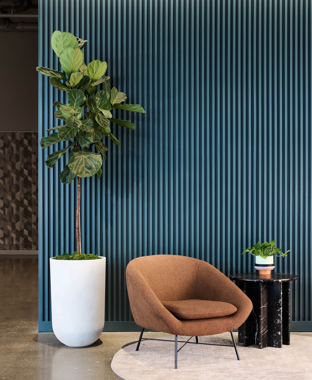 A living room with a brown chair and a potted plant.