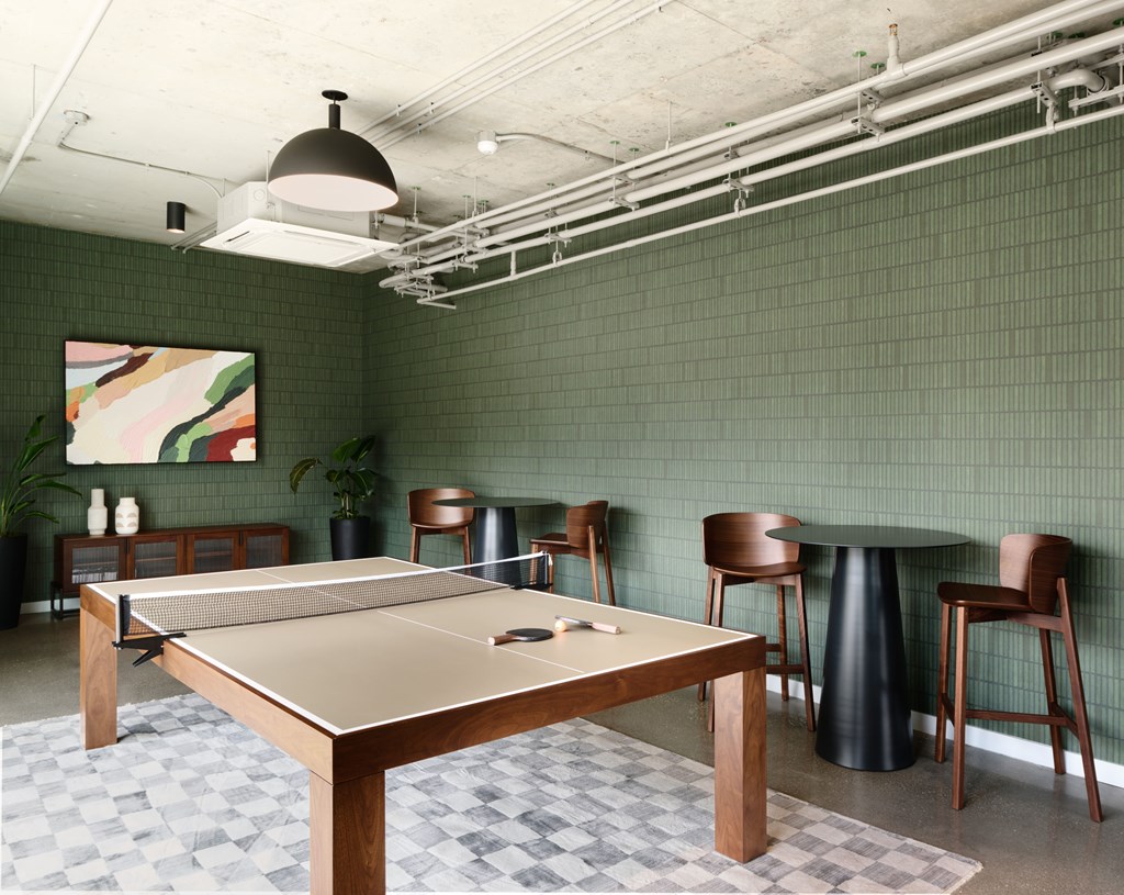 A ping pong table is in the middle of a room with green walls.