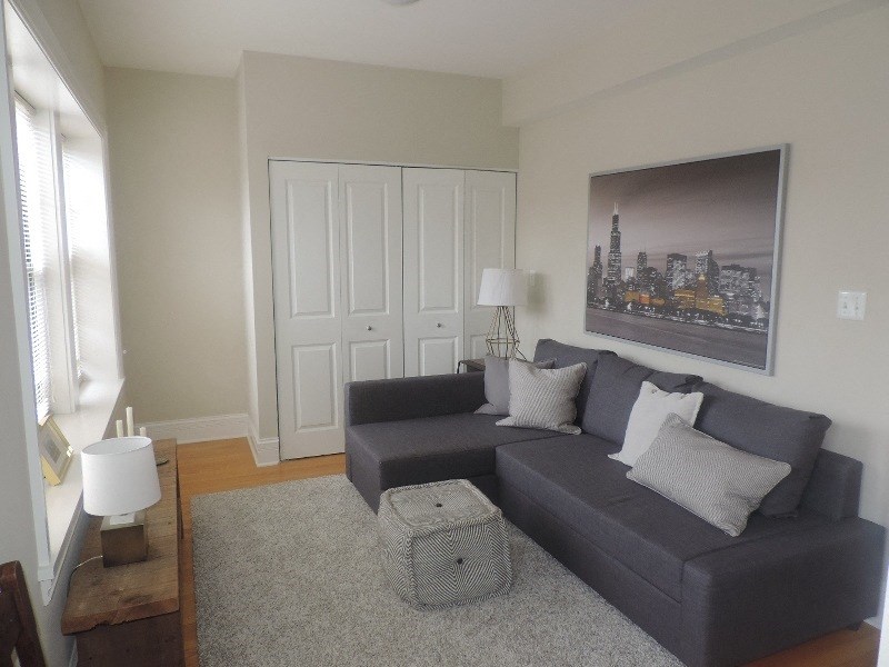 a living room with a gray couch and a rug