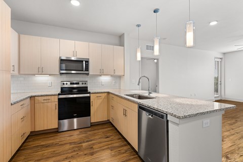 A kitchen with wooden cabinets and granite countertops.