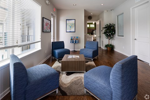 A living room with blue chairs and a coffee table.
