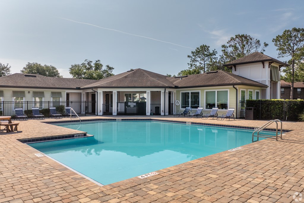 A swimming pool in a backyard with a house in the background.