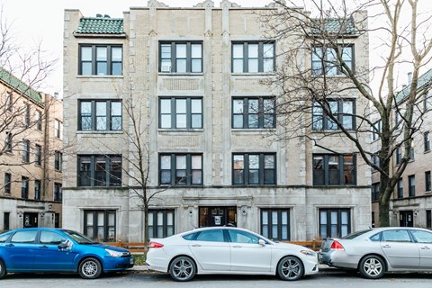 Three cars parked in front of a building.