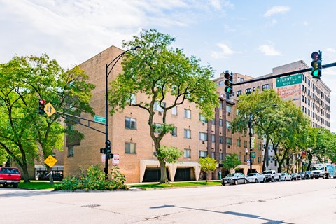 a large brick building on the corner of a street with traffic lights