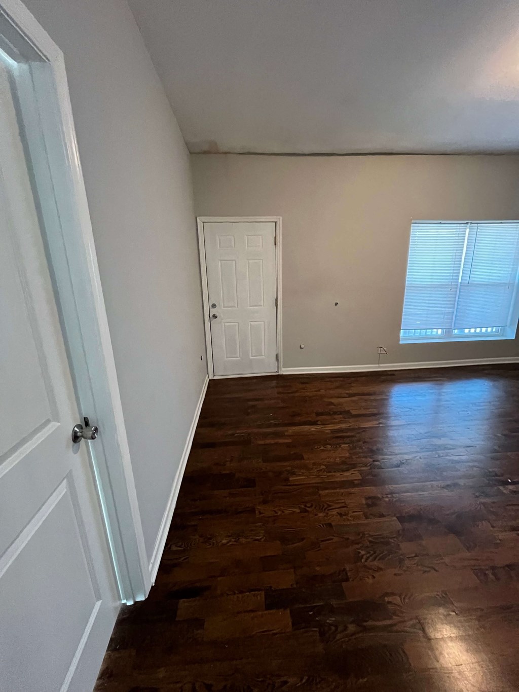 a living room with wooden floors and a white door