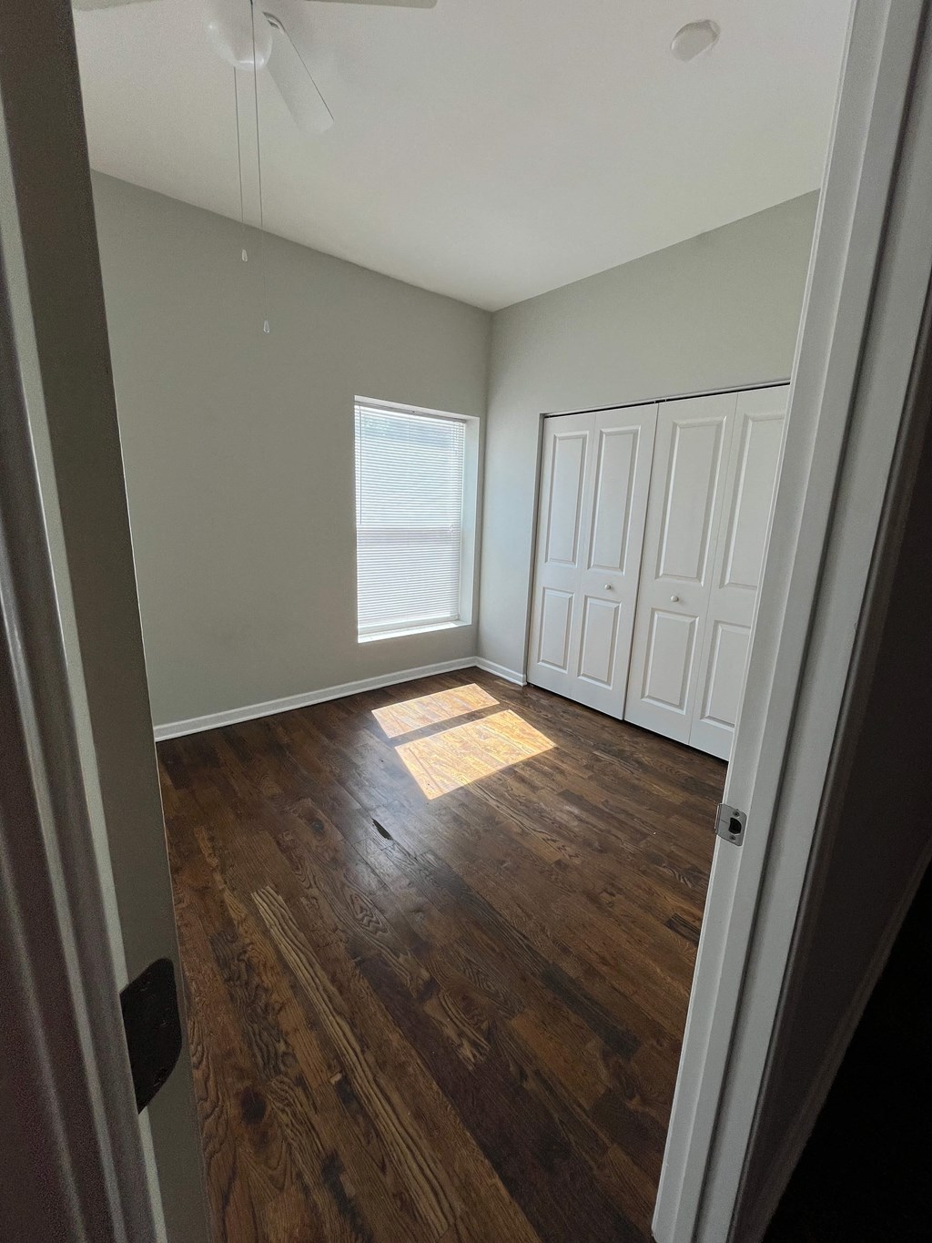 an empty room with wooden floors and white walls