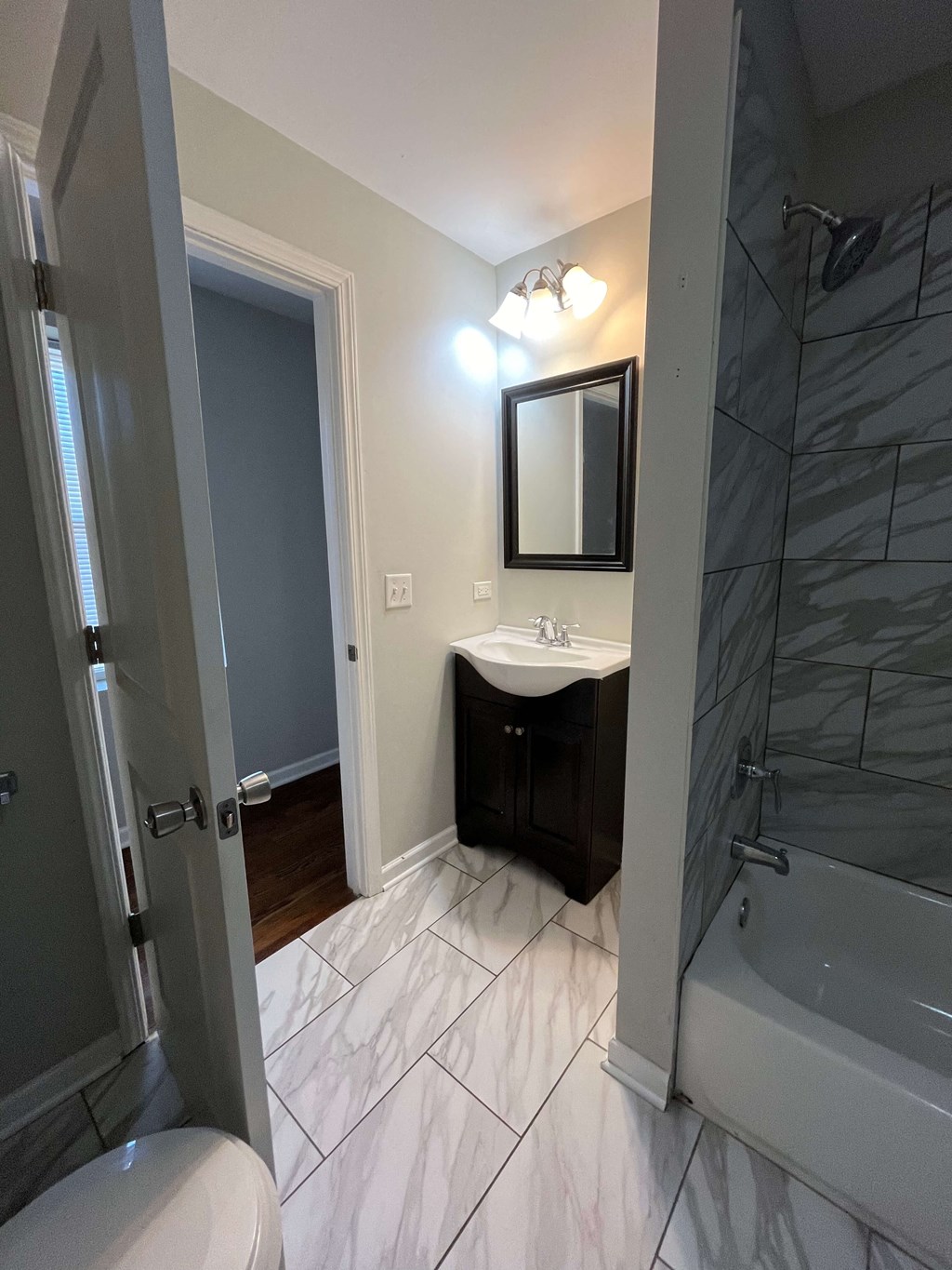 a bathroom with a shower sink and toilet and a mirror