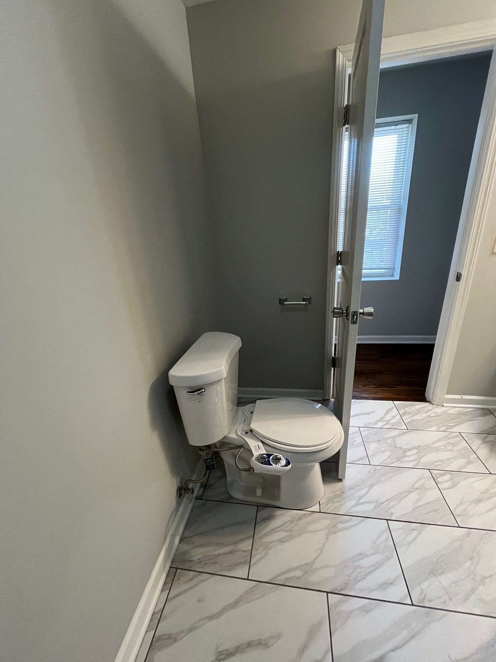 a bathroom with a toilet and an open door