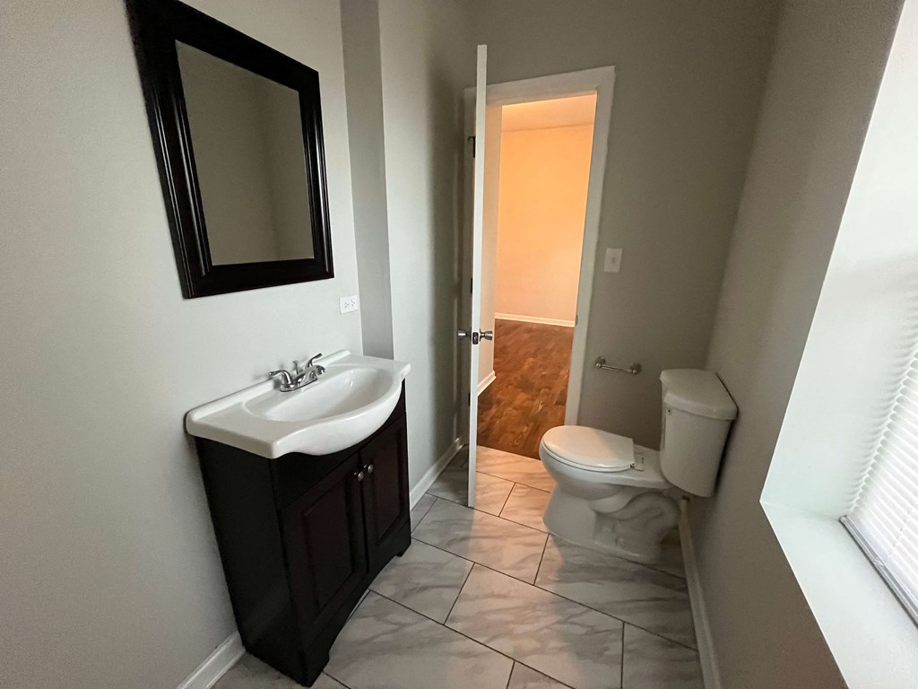 a bathroom with a sink toilet and a mirror
