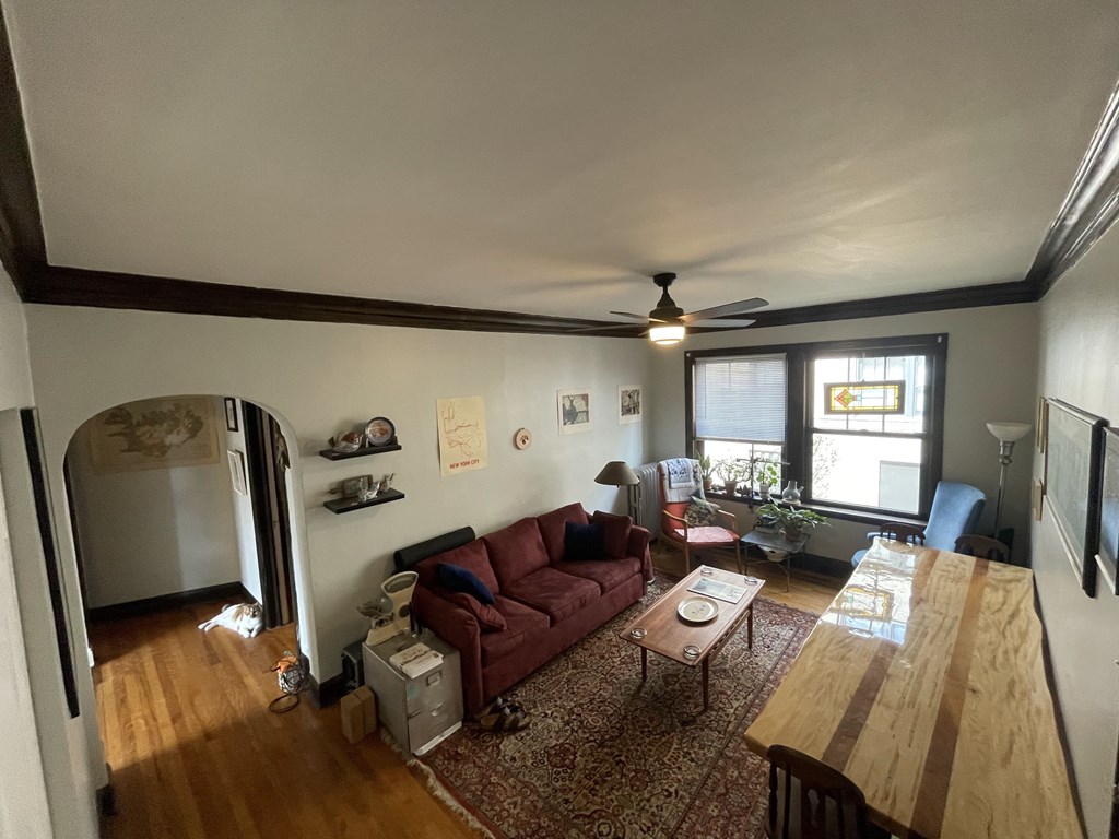A living room with a red couch and a wooden table.