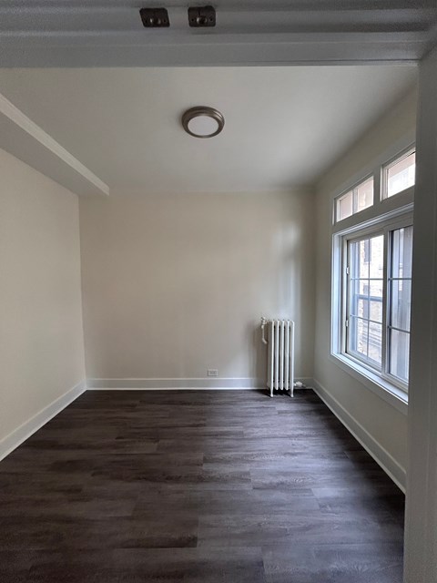 A room with a window and a radiator on the wall.