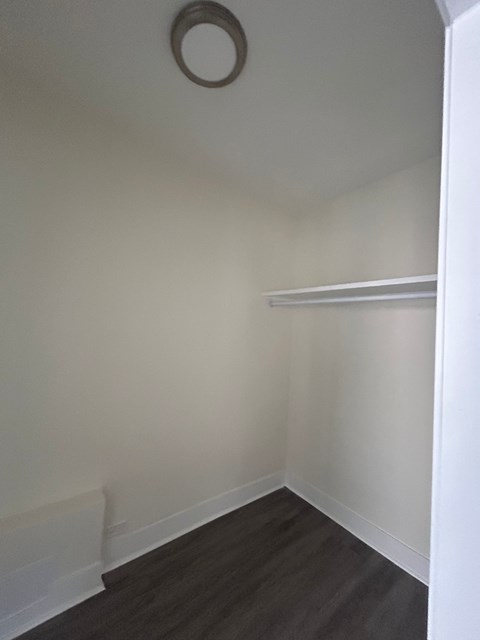A small room with a white wall and a shelf.