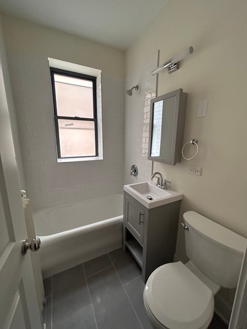 A bathroom with a toilet, sink, and bathtub.