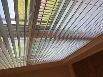 A close up of a white ceiling with a grid of square panels.
