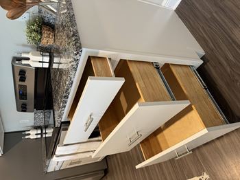 A modern kitchen with a stainless steel refrigerator and wooden drawers.