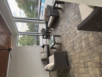 A patio with a brick wall and a ceiling fan.