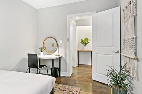 a bedroom with a bed and a desk with a mirror