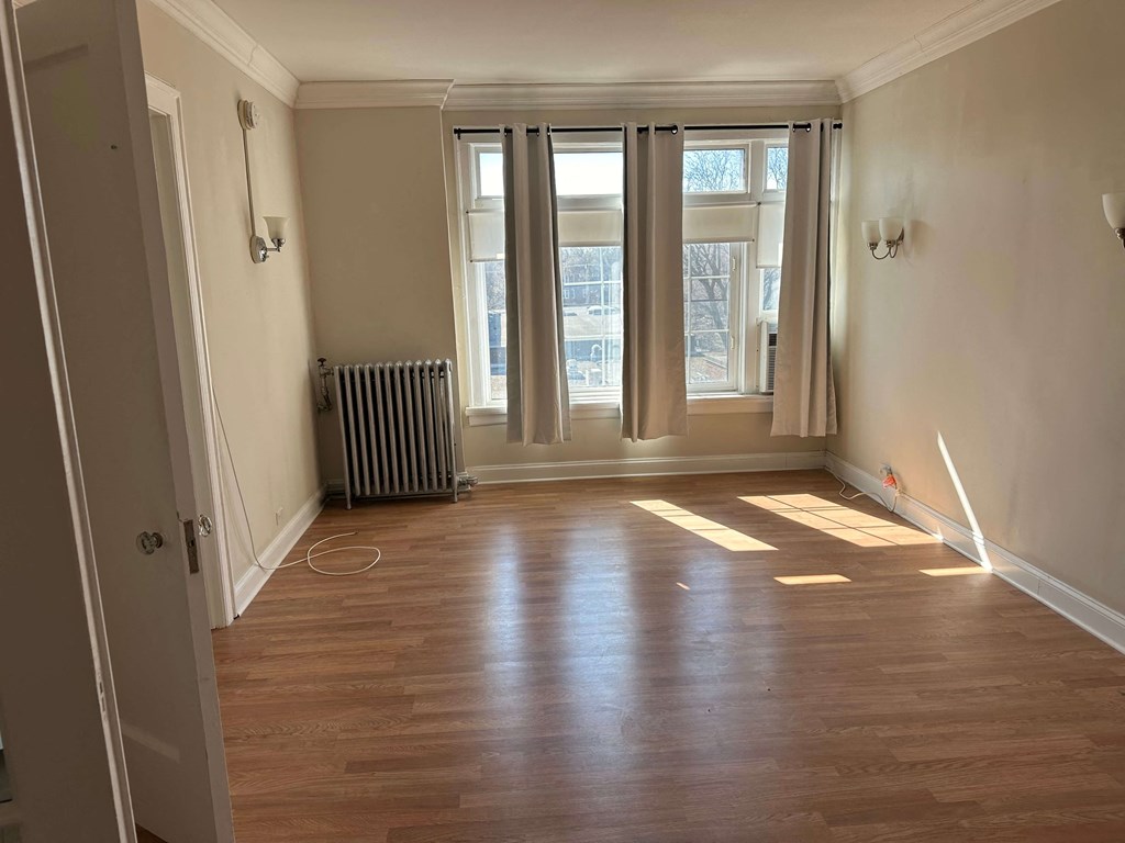 a living room with wood floors and a window