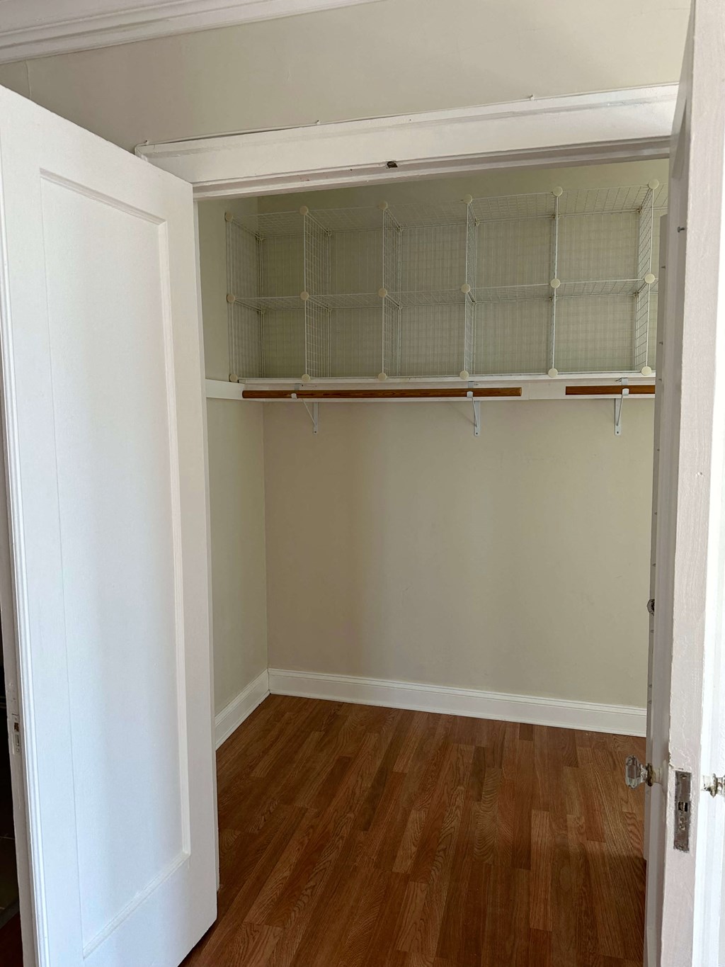 an empty closet with shelves and a wood floor