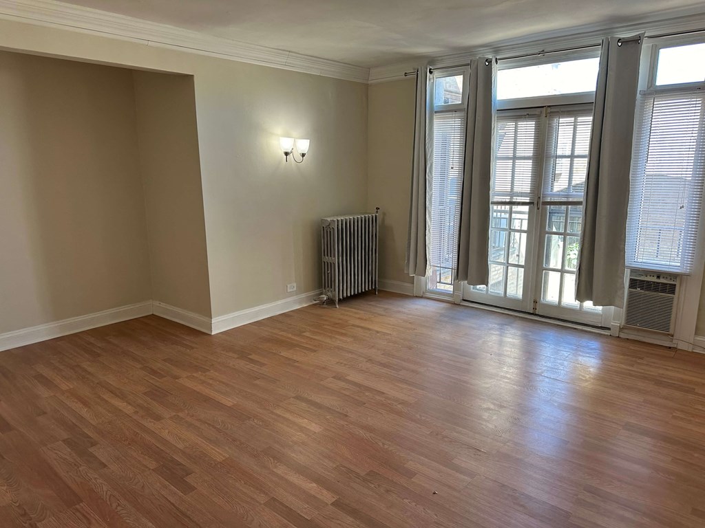an empty living room with wood floors and windows