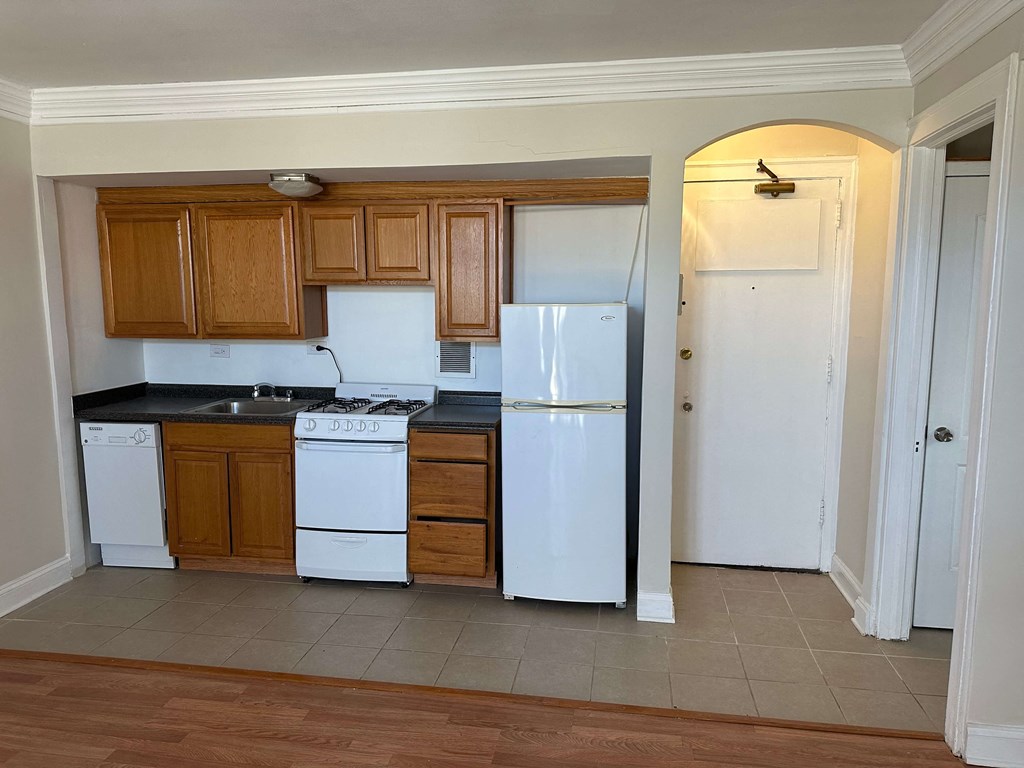a kitchen with white appliances and wooden cabinets