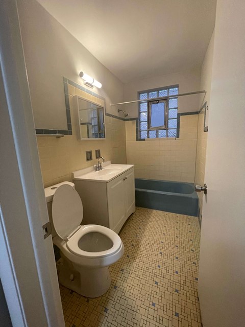 A bathroom with a toilet, sink, and bathtub.