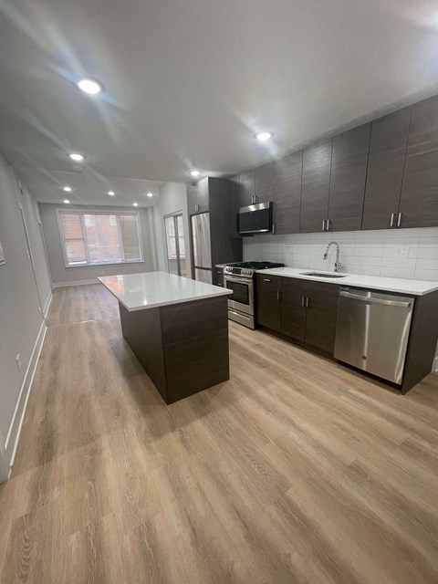 a kitchen with an island and stainless steel appliances
